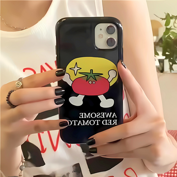 Person holding a phone with a cartoon tomato design on a black case.
