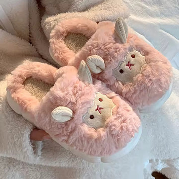 Pink fluffy slippers with bunny design on a soft white background