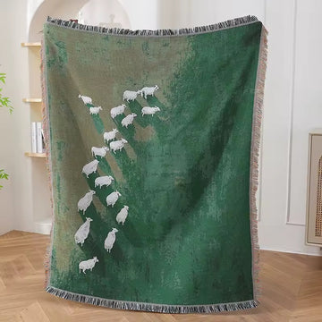 Rustic woven sheep tapestry blanket draped over a sofa for cozy farmhouse decor.