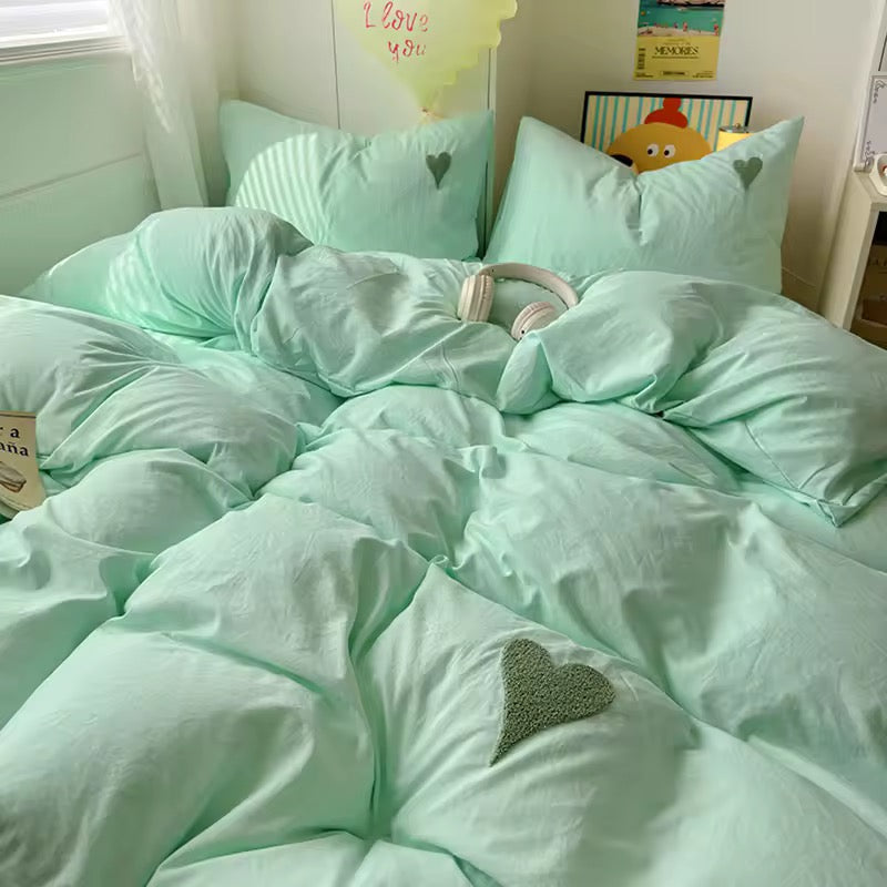 4-piece mint pastel bedding on bed with heart embroidery on pillows