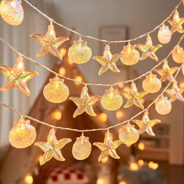 Decorative string lights with starfish and shell designs on a blurred background