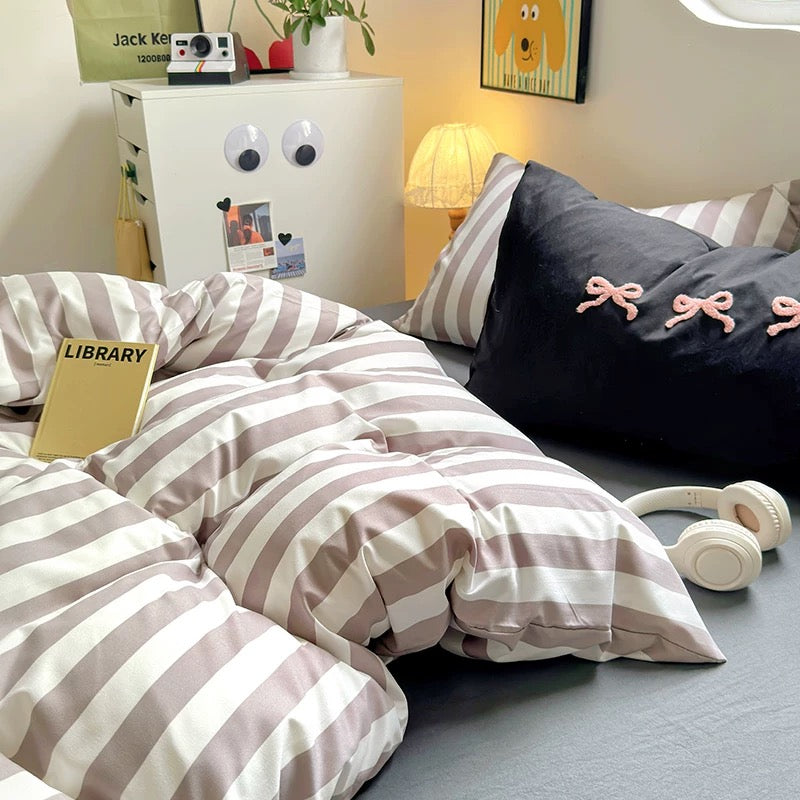 Black striped bedding set with cream accents styled in a coquette dorm room