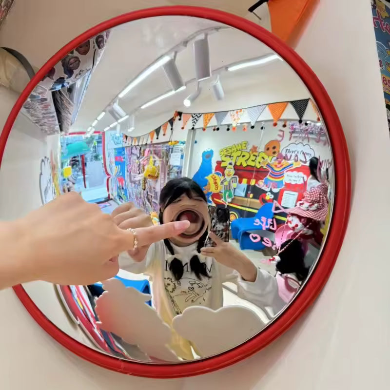Person taking a mirror selfie in a colorful room with decorations.