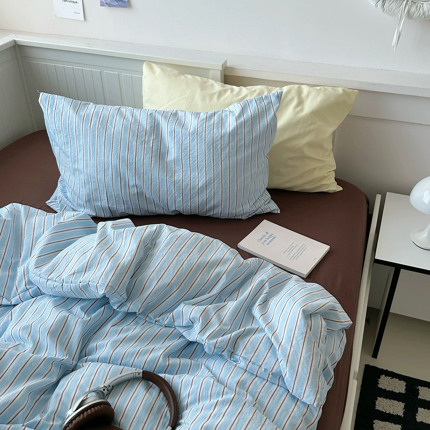 Bed with striped bedding and pillows in a bedroom setting