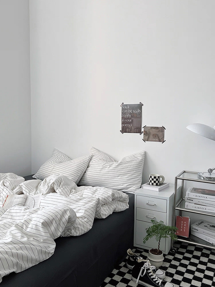 Bedroom with black bed, white bedding, and a checkered floor.