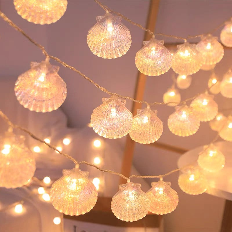 String of shell-shaped fairy lights against a blurred indoor background