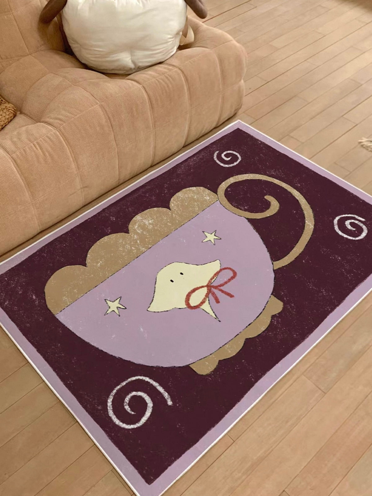 A bedside rug design with a lilac cup, yellow jellyfish and curled handle appears beside a tan sofa.