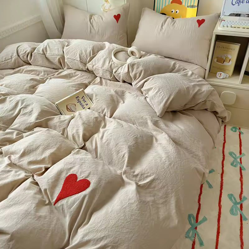 Minimalist bedroom with white heart cotton bedding and neutral tones.