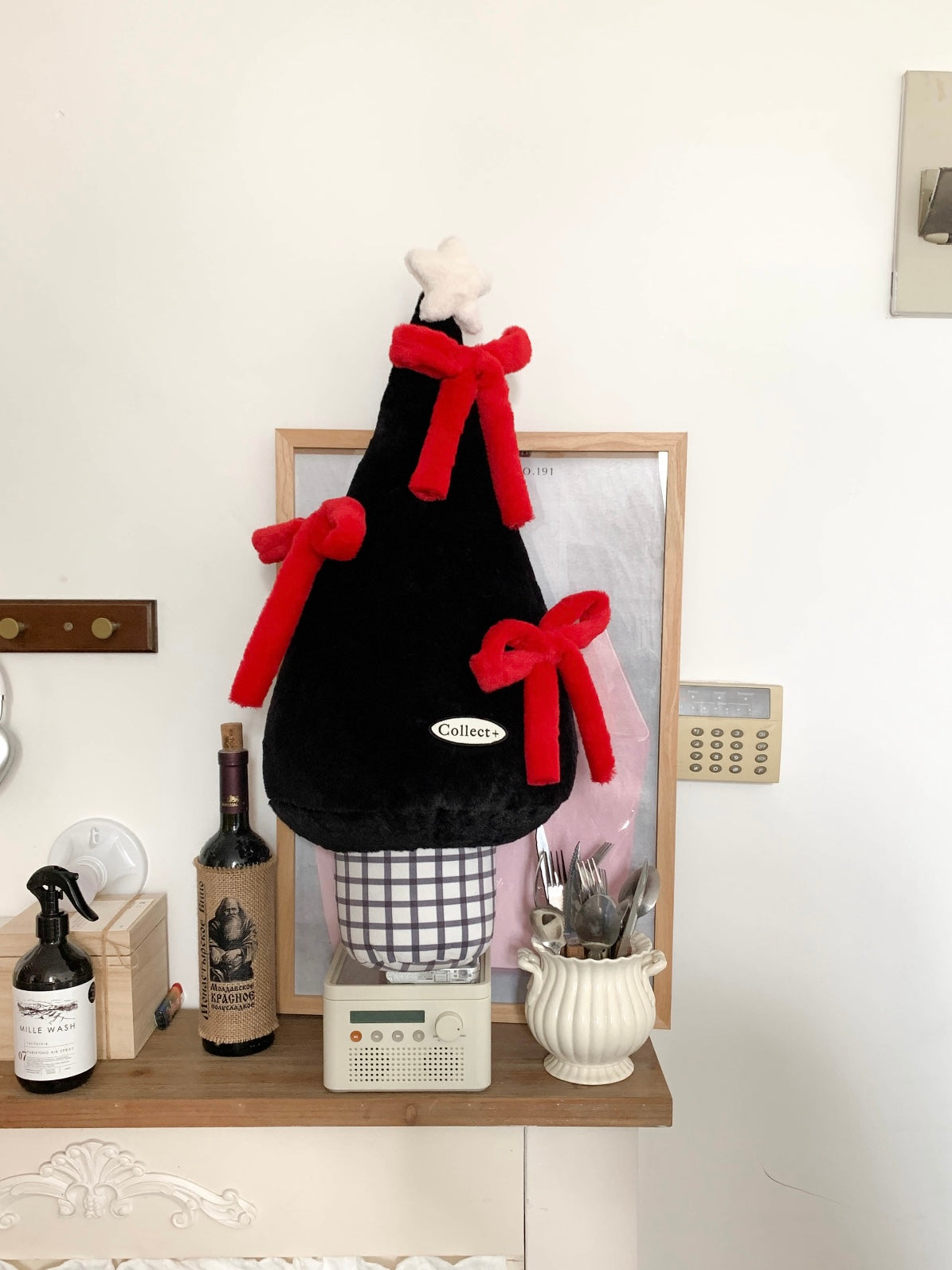 Black Christmas tree pillow with oversized red bows in a living room setting