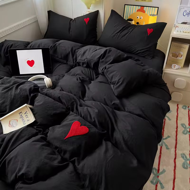 Flat lay of 4-piece bedding set including duvet cover, flat sheet, and pillowcases.