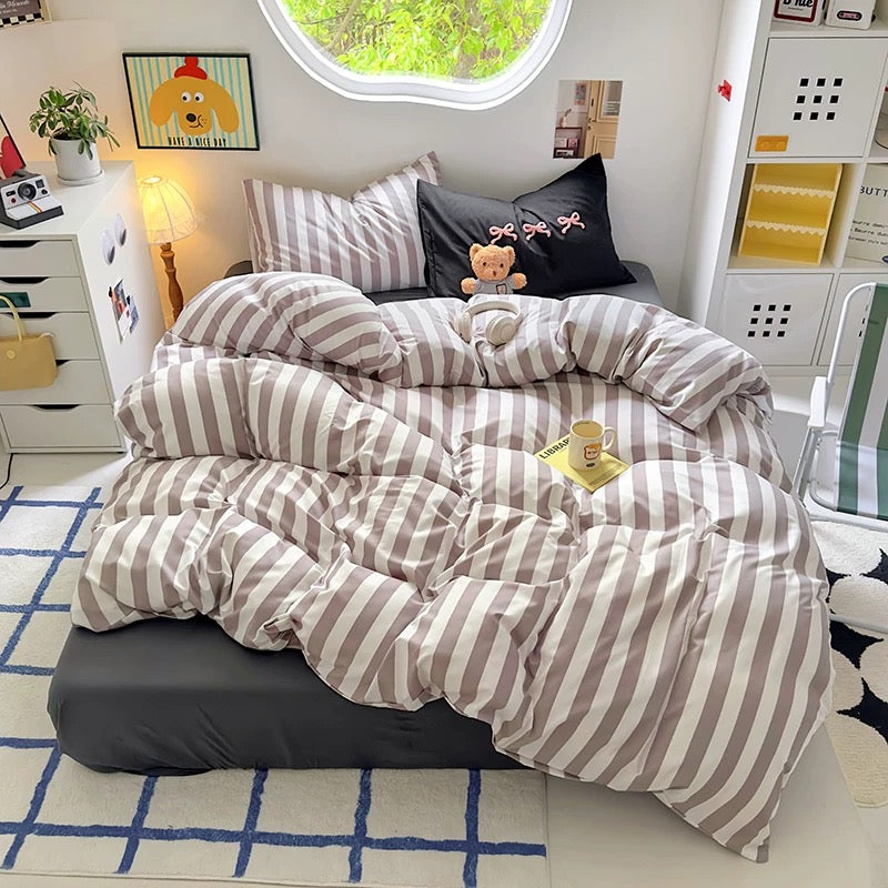 Black striped bedding set with cream accents styled in a coquette dorm room