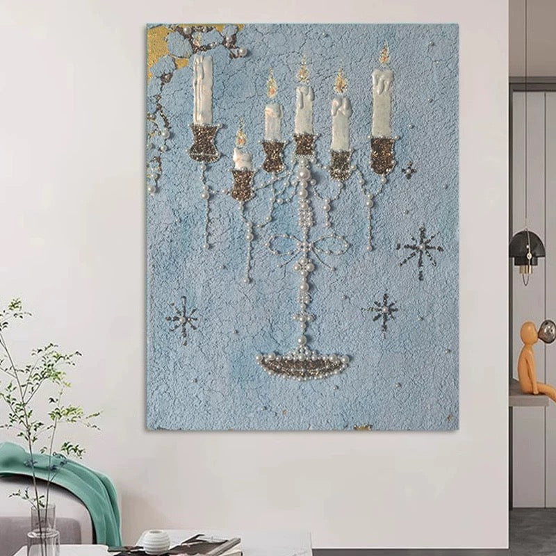 Blue candle wall art hanging beside a doorway above a table with flowers