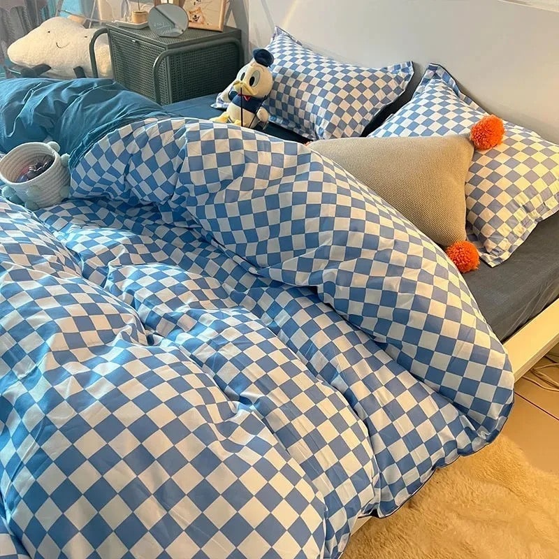 Black and white checkerboard bedding set styled on a bed with matching pillowcases