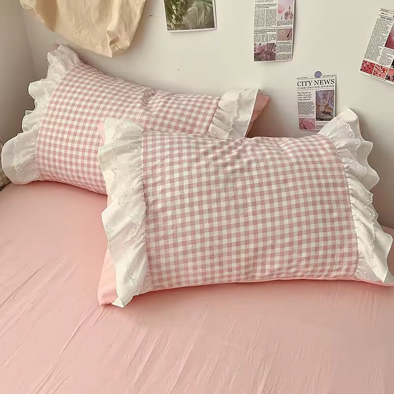 Dorm room with gingham quilt cover and wall posters in coquette style
