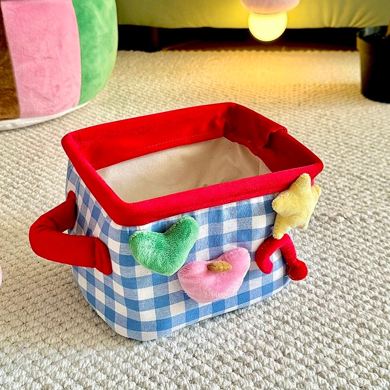 Blue plaid storage basket open with red rim and colorful decorative shapes