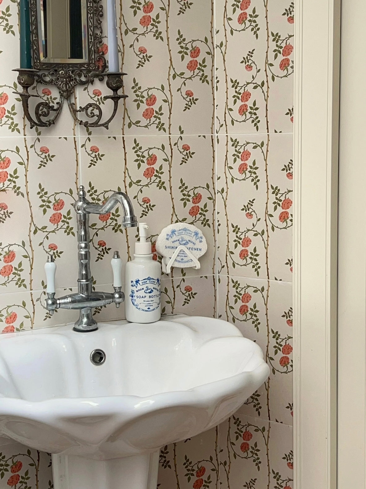 Blue soap dispenser appears beside a white sink in a wider view, with a matching sponge mounted above it.