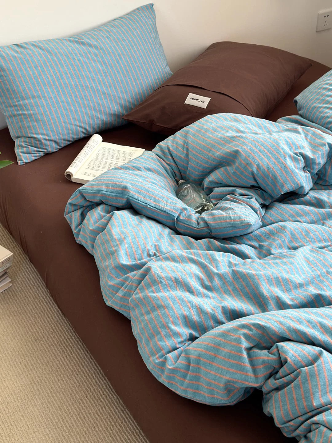 Blue striped duvet cover on bed – minimalist coastal bedding set with pillowcases, gender-neutral dorm aesthetic.