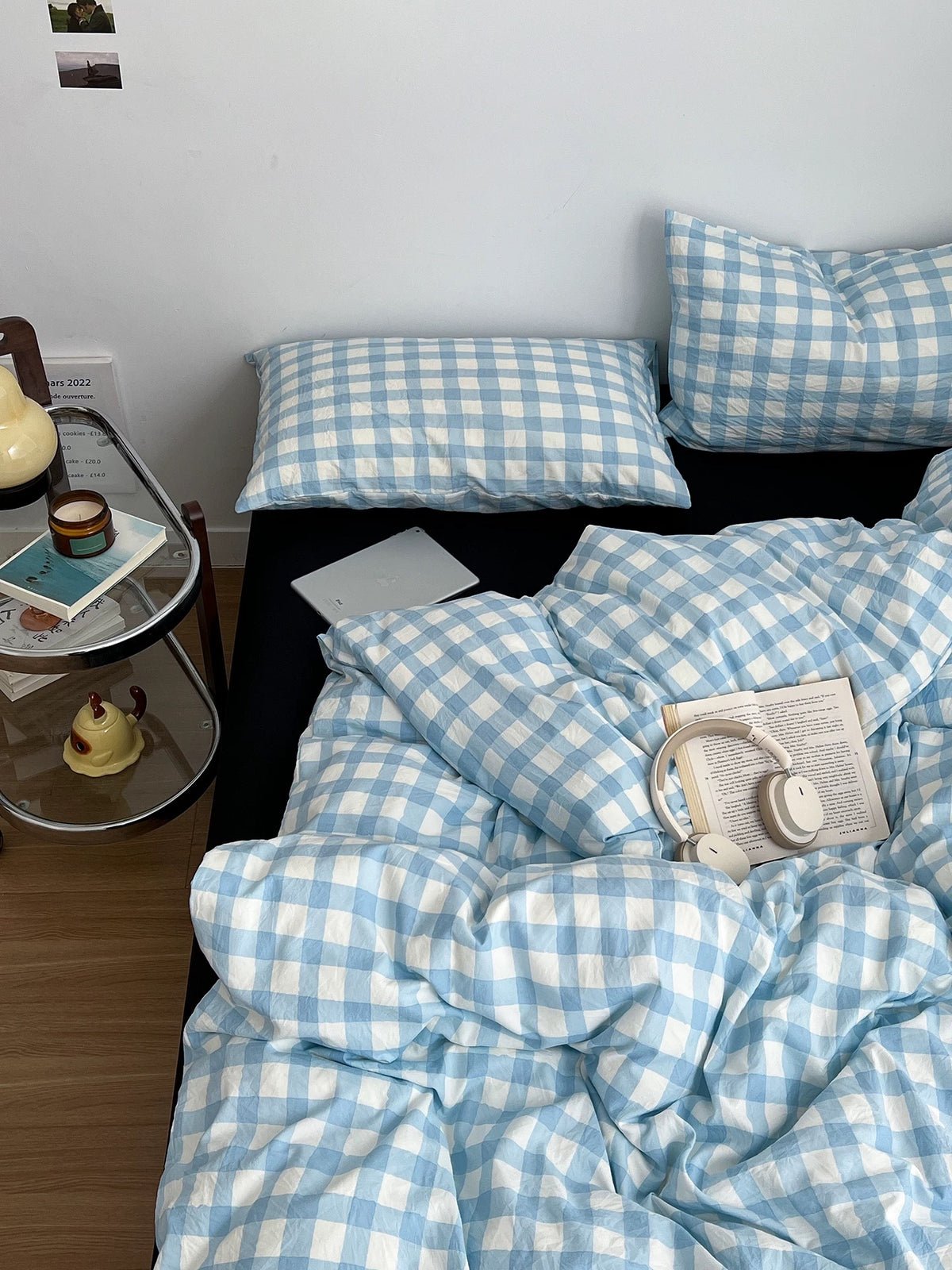 Blue and white gingham bedding styled with black pillows in a simple bedroom