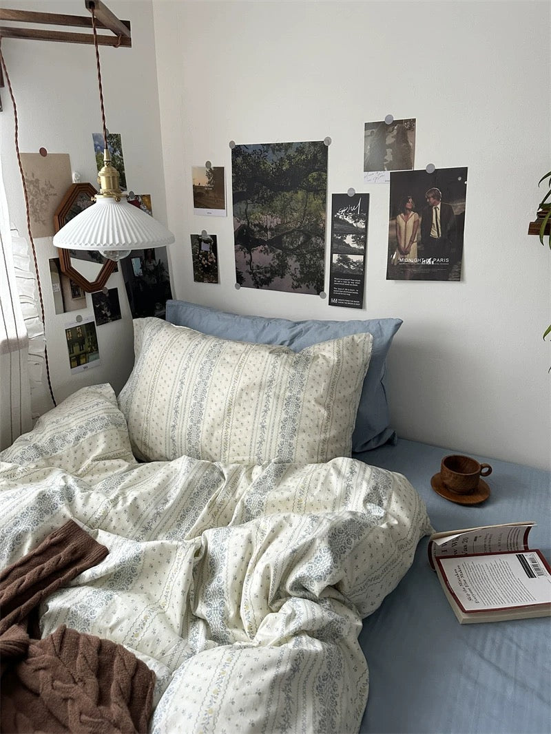Blue floral cotton bedding set with vintage stripe pattern creating soft Scandinavian inspired bedroom atmosphere every season.