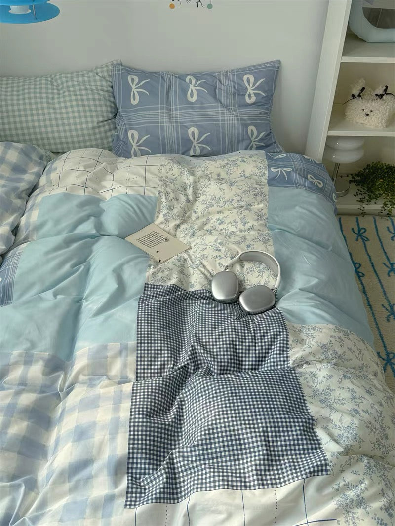 Bedding set with checkered pillowcases and a bow design on a bed.