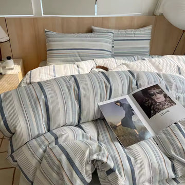 Striped bedding with a magazine on a bed in a bedroom setting