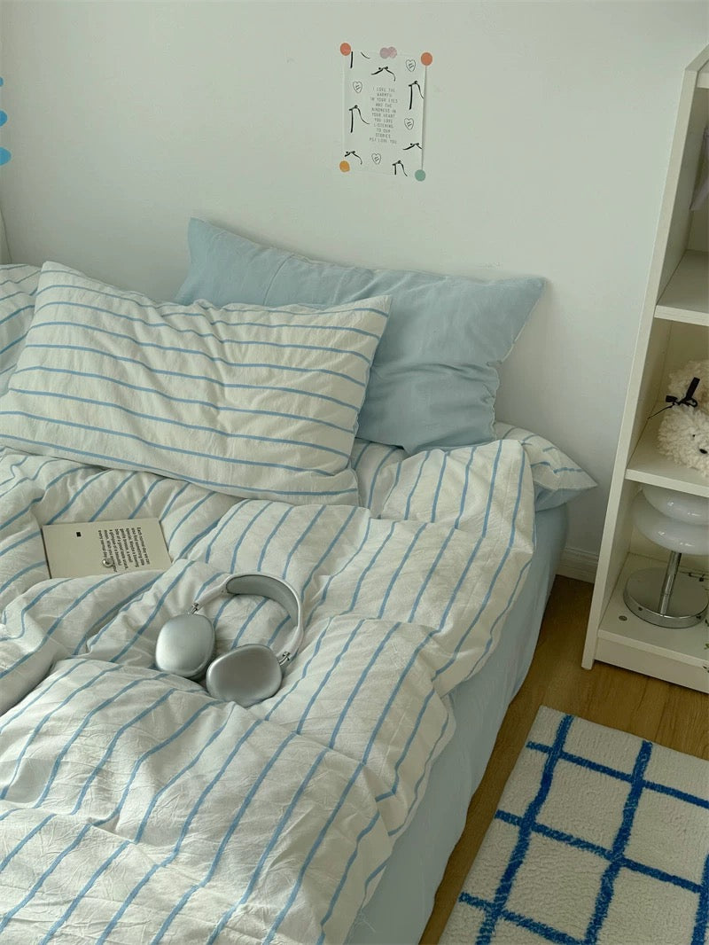 Bedroom with striped bedding and a rug on the floor