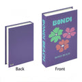Travel book box stack styled as a coffee table centerpiece in Danish pastel tones.