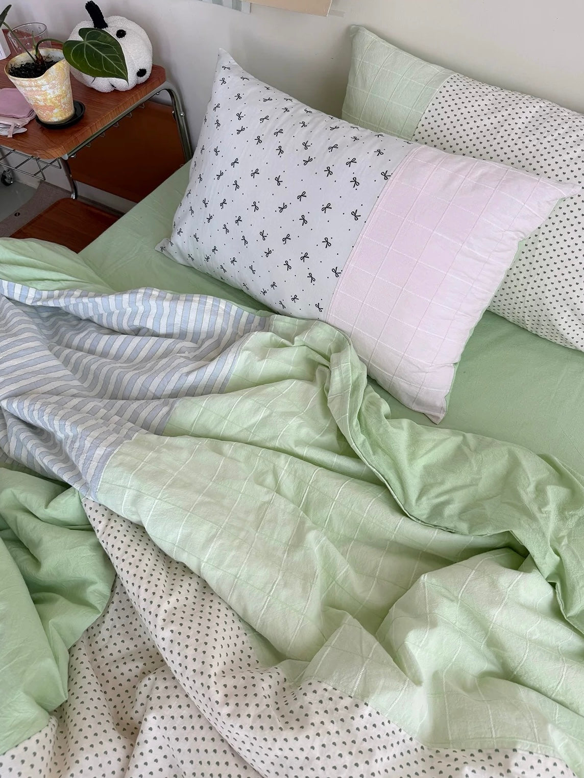 White bow-print pillowcase with pink and green cotton bedding