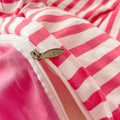 Close-up of a pink and white striped garment with a zipper detail.