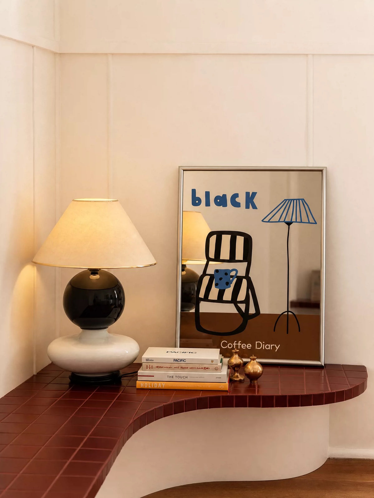 A brown and blue chair mirror rests upright on a desk, showing a black chair and an illustrated floor lamp.