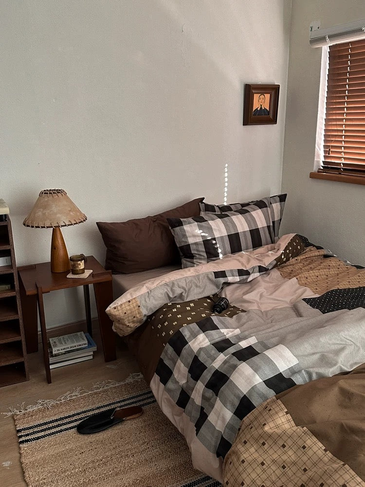 Brown gingham bedding with layered pillows in a cozy preppy bedroom