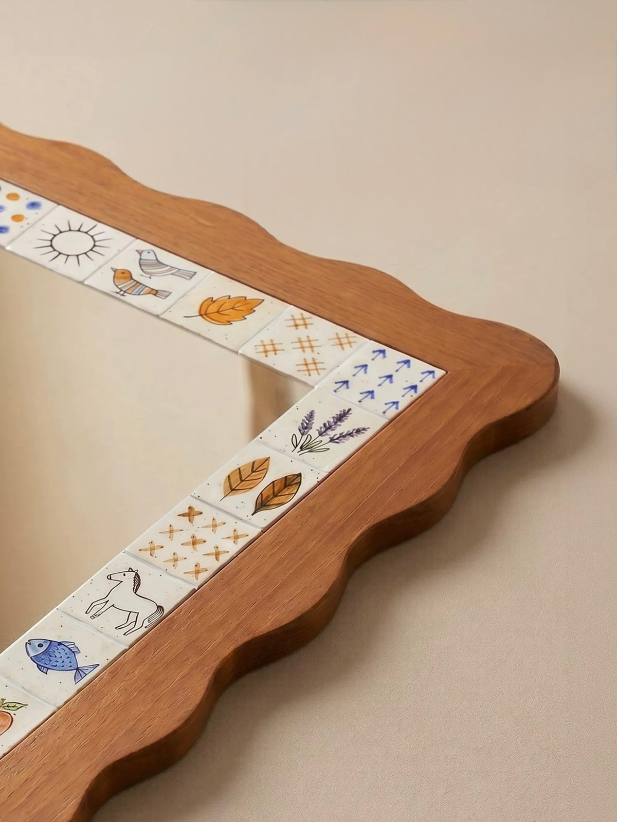 A close view of the brown scalloped mirror shows its curved corner and small illustrated border panels.