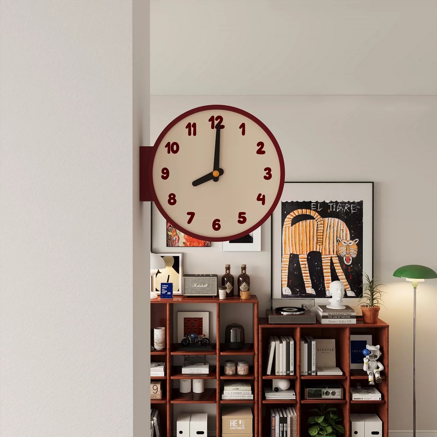 Wall clock on a shelf with decorative items against a light gray wall