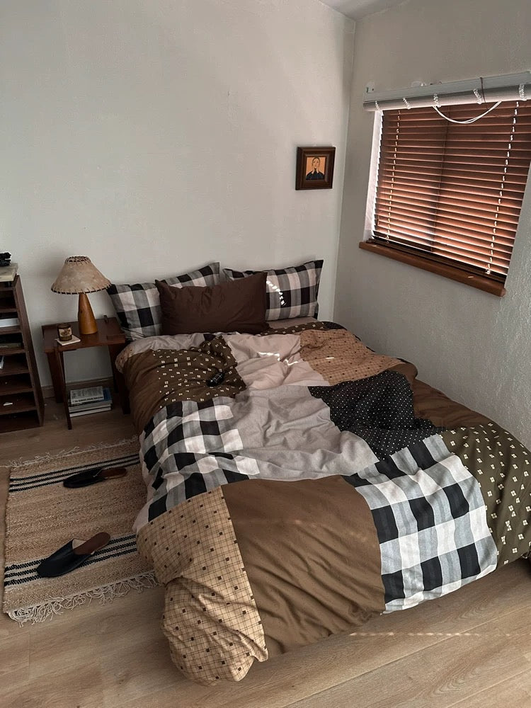 Caramel brown plaid bedding with large checks draped over the foot of the bed