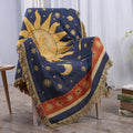Decorative blanket with celestial design draped over a chair in a room.