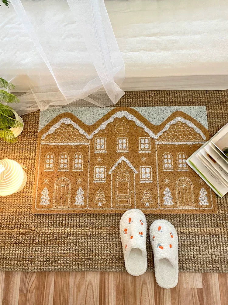 Gingerbread house Christmas entryway rug styled on a woven floor rug