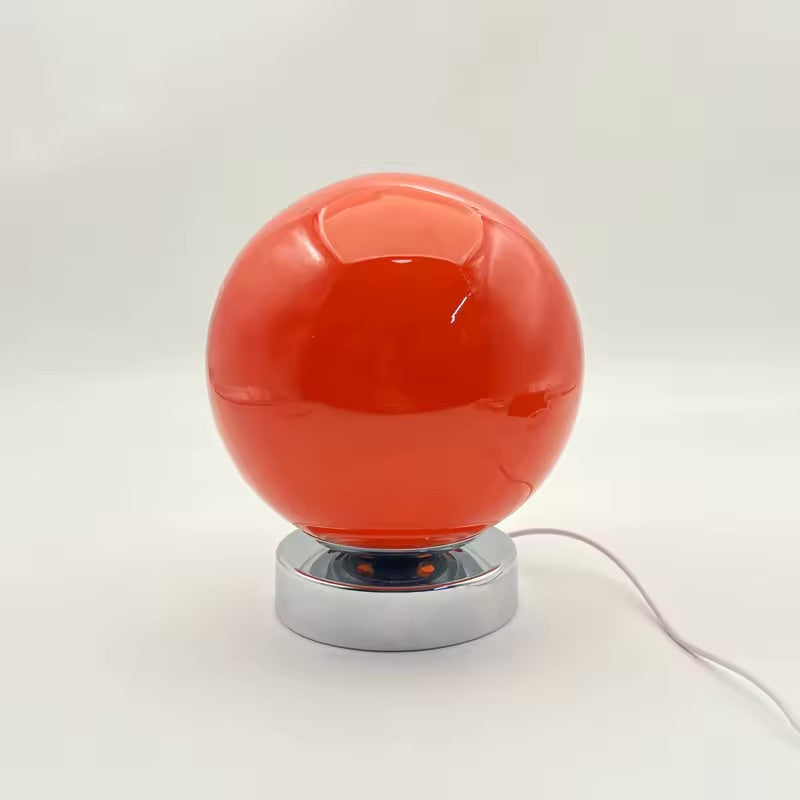 Red spherical lamp with a silver base on a white background