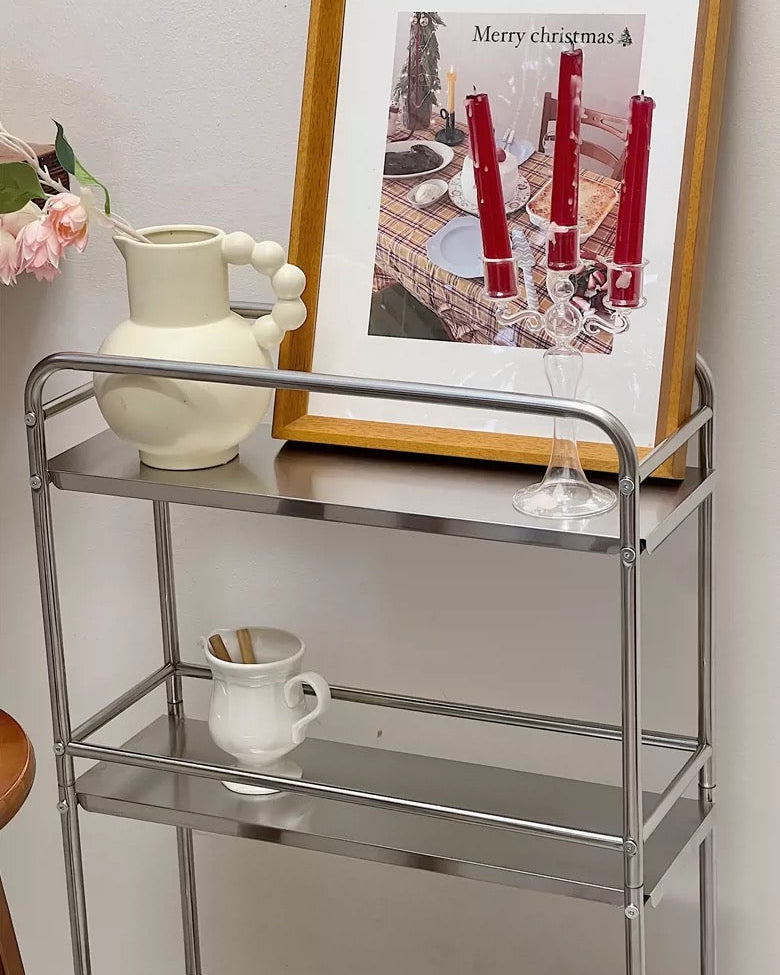 Three-tier stainless steel shelf cart with rounded rails and polished silver finish for home.