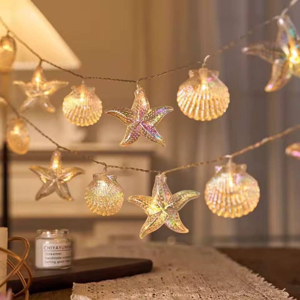 Decorative string lights with starfish and shell designs on a table.