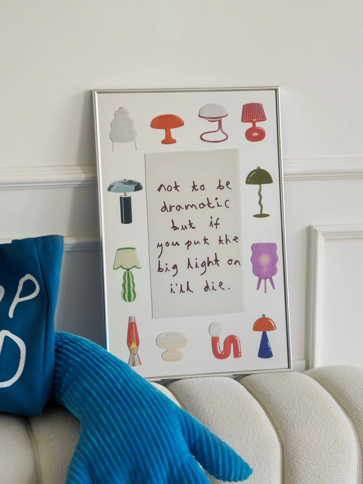 A colorful lamp mirror leans against the wall, with illustrated shades and bases surrounding a handwritten message.