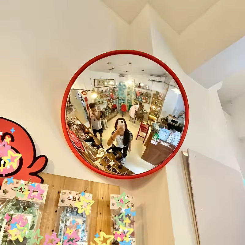 Person holding a round mirror with colorful decorations and cartoon characters.