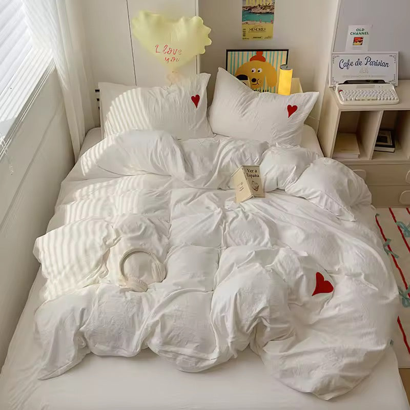 White heart embroidered duvet cover set displayed on a cozy bed with pastel decor