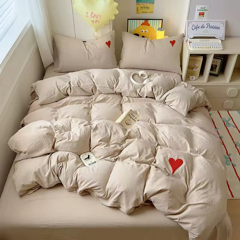 Minimalist bedroom with white heart cotton bedding and neutral tones.