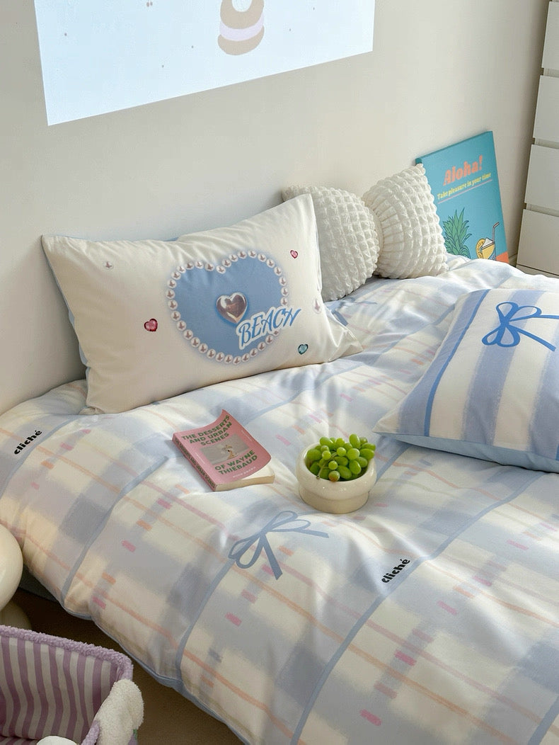 Bed with checkered bedding and decorative pillows in a room setting