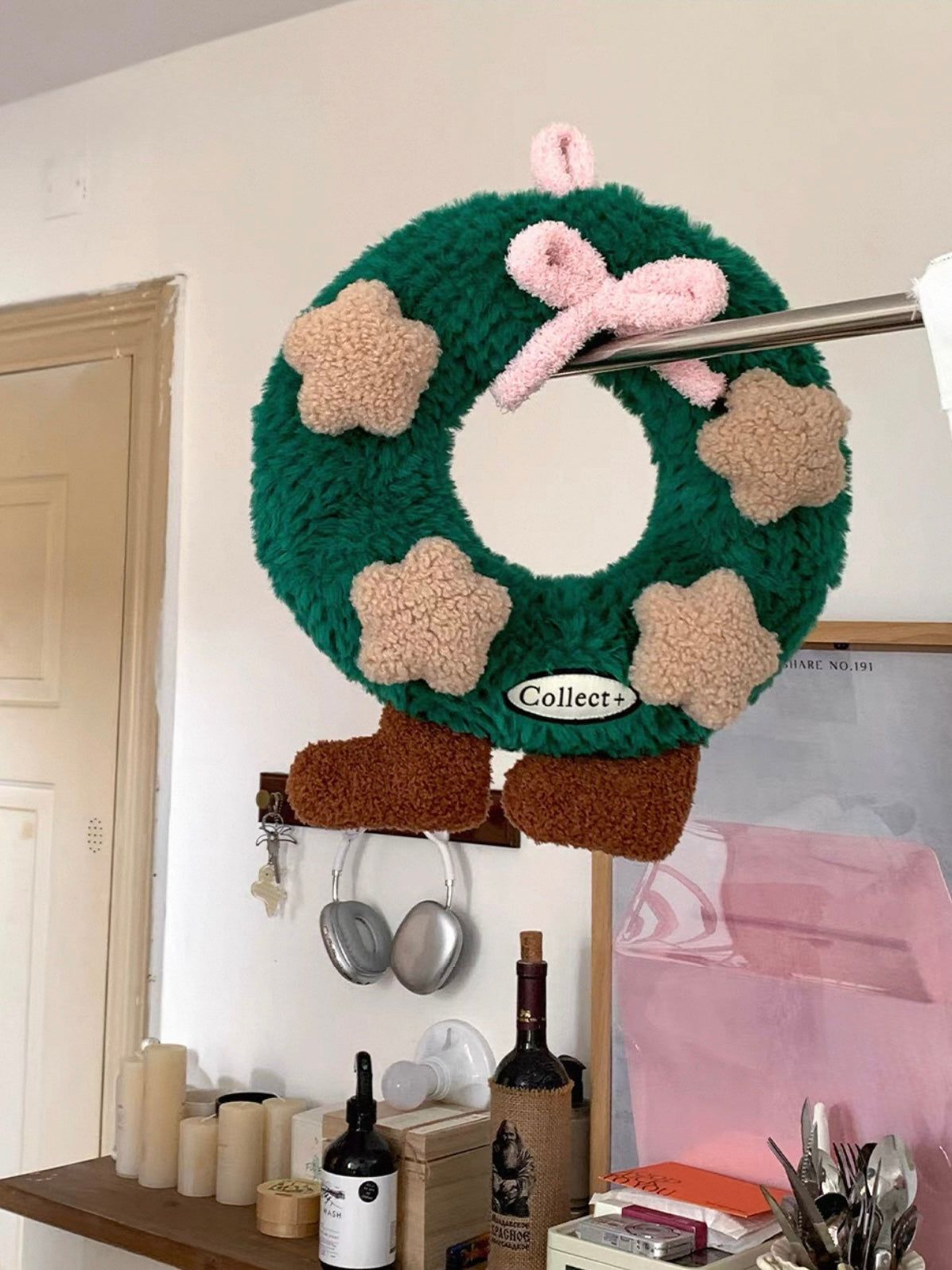 Coquette Christmas wreath pillow with oversized pink bow, soft star details and brown feet