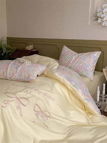 Bed with pastel-colored bedding and decorative pillows in a bedroom setting.
