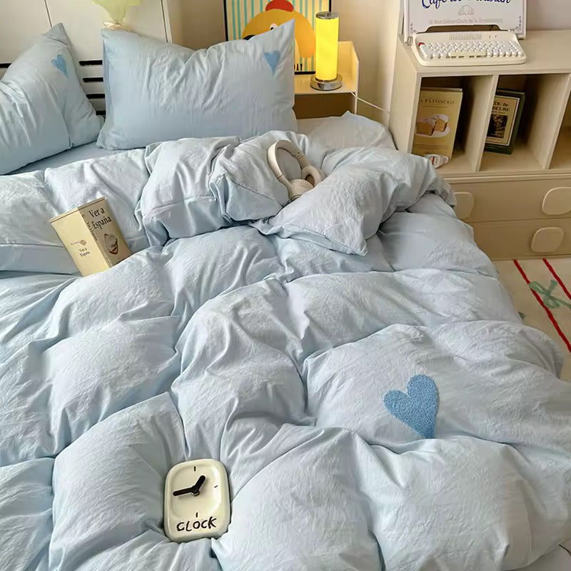 Coquette bedroom setup with heart bedding and soft lighting.