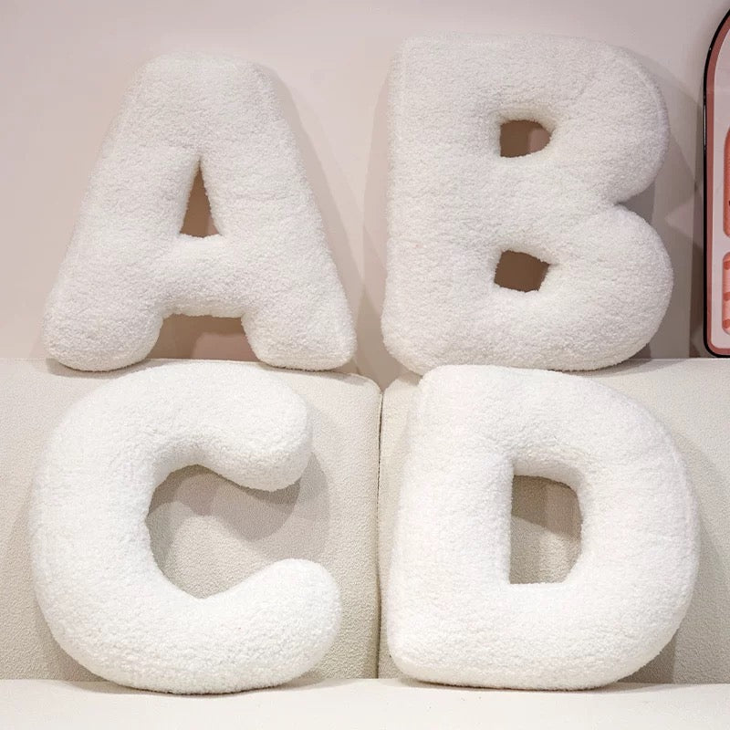 White letter pillows spelling 'ABCD' on a light background
