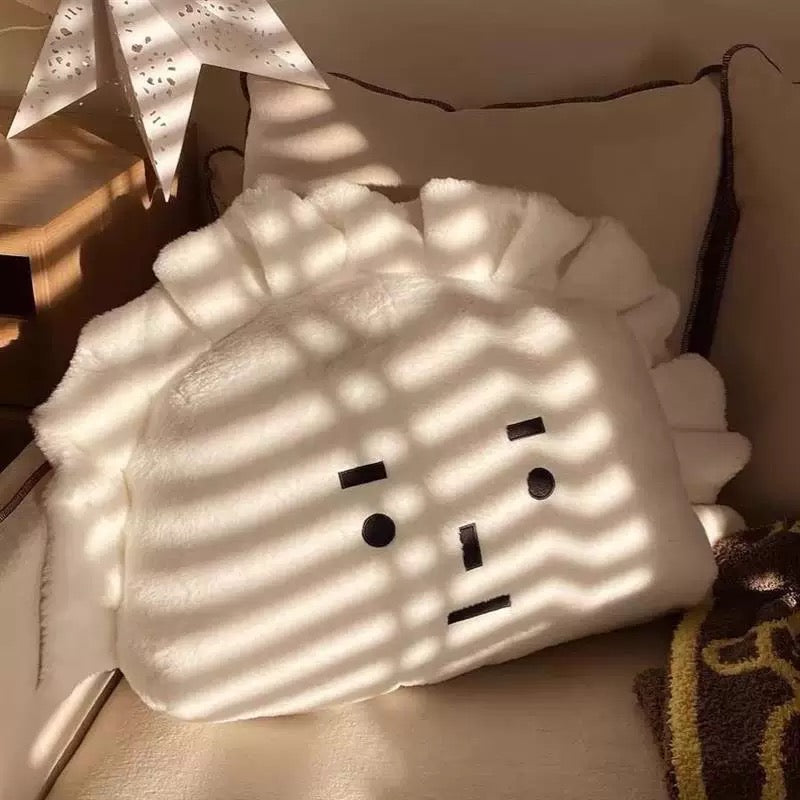 White pillow with a face design on a couch