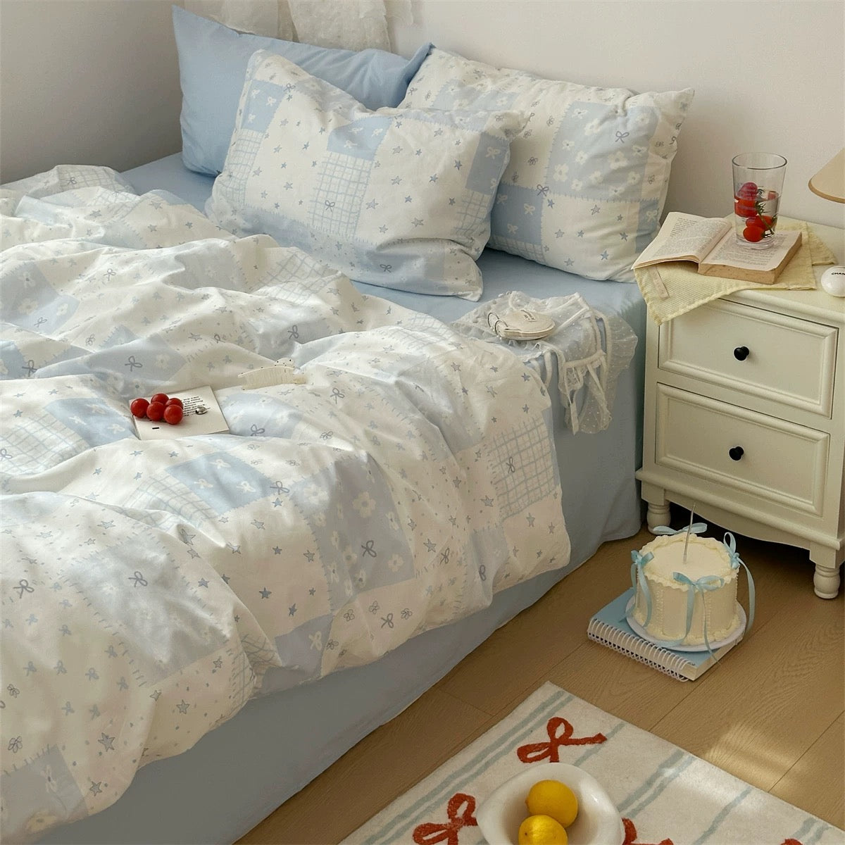 Cozy apartment bedroom with pastel blue duvet cover set and lace curtains.